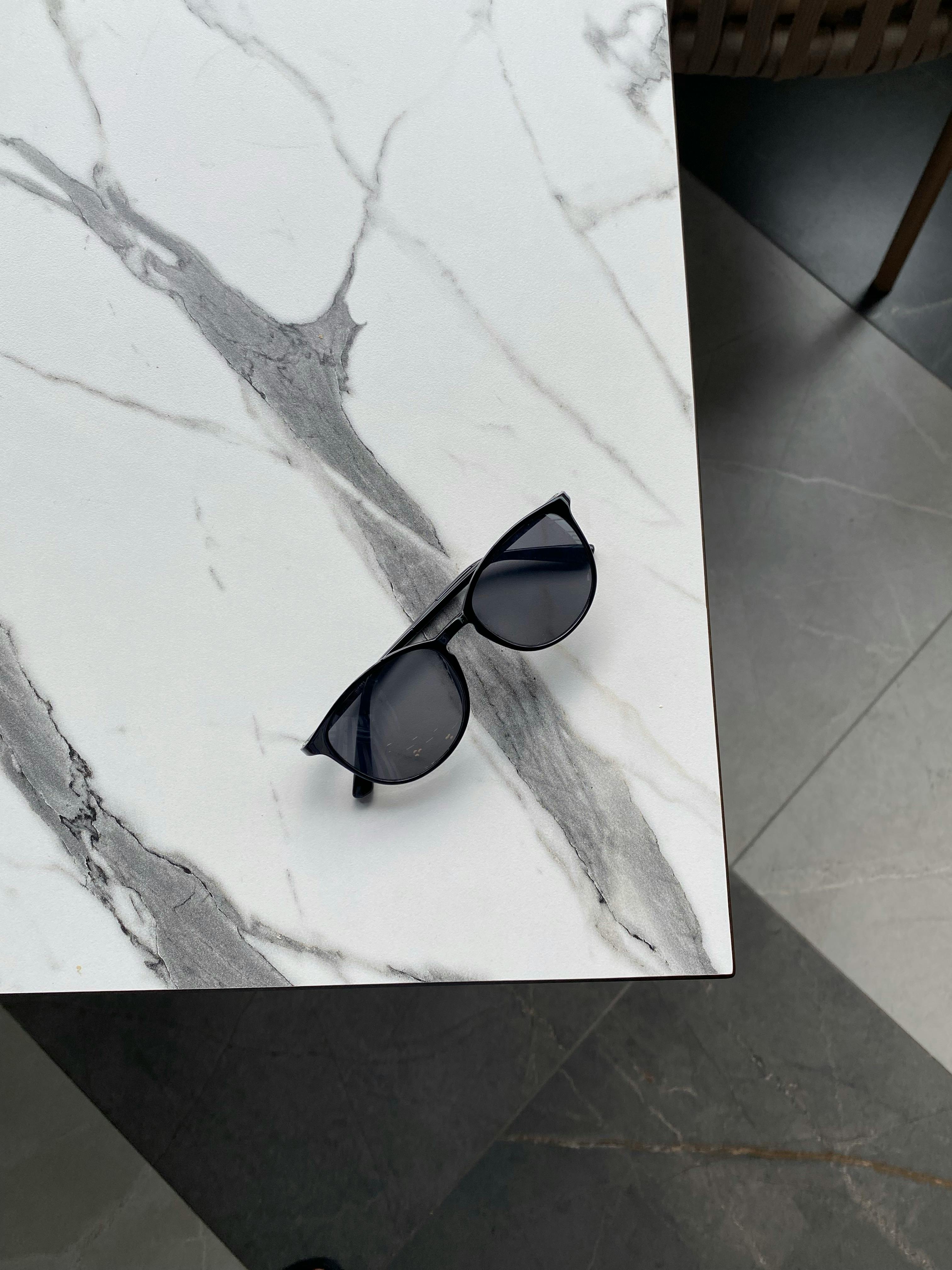 Single pair of quality sunglasses on a clean marble surface