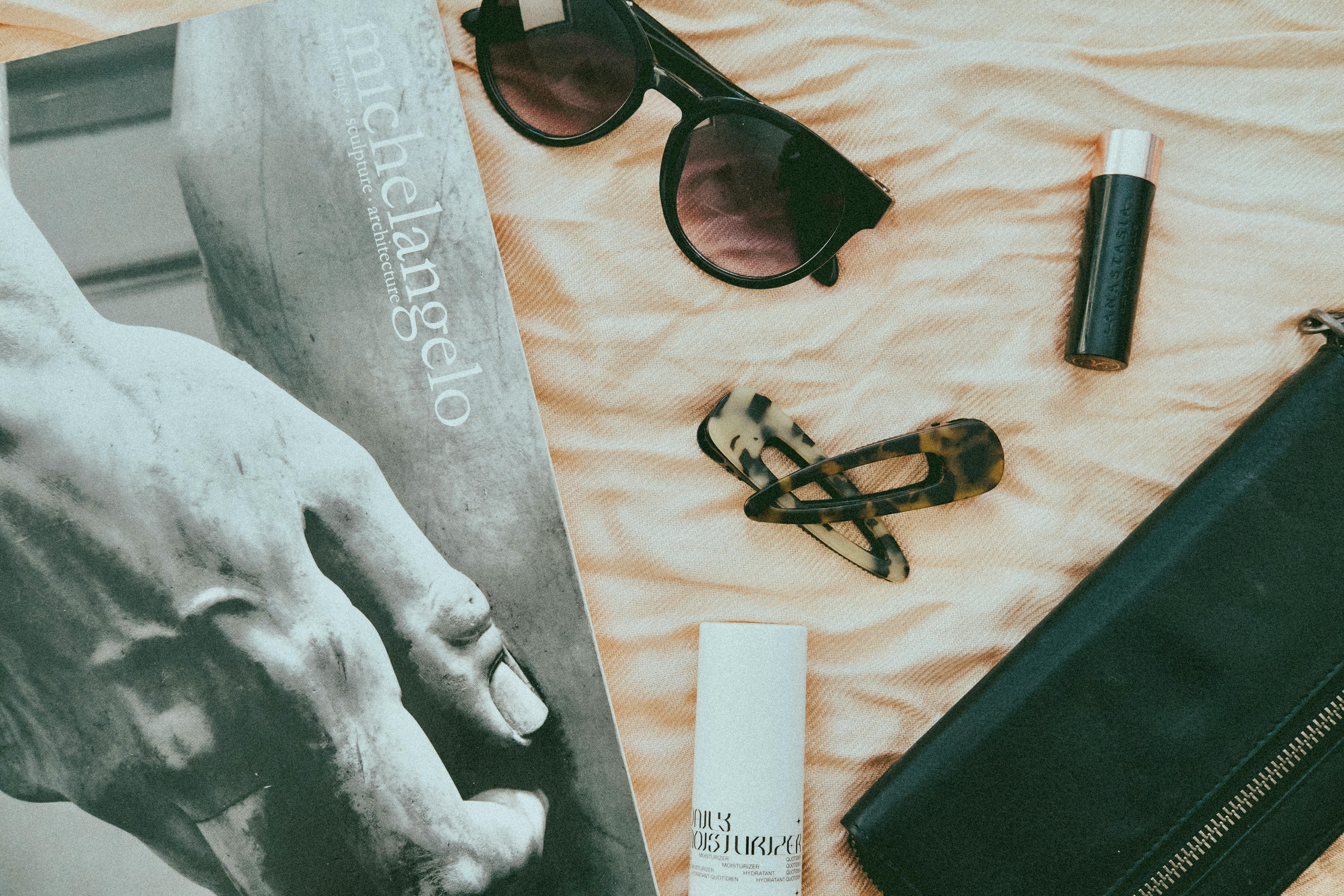 Flat lay of outfit pieces with sunglasses as the centerpiece